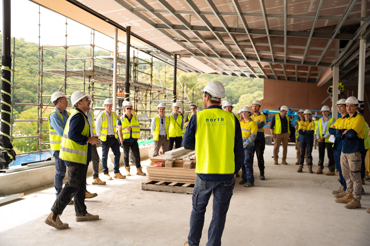 A photo of the team at North having a large meeting in a construction site. North Construction and Building.