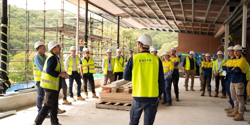 A photo of the team at North having a large meeting in a construction site. North Construction and Building.